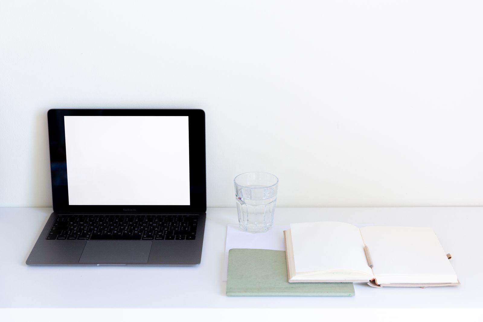 Laptop and open notebook on an office desk